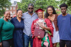 Adult Graduate Student Smiling Surrounded By Family.