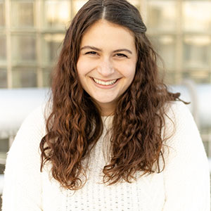 Ally Cefalu smiling at the camera in a white shirt.
