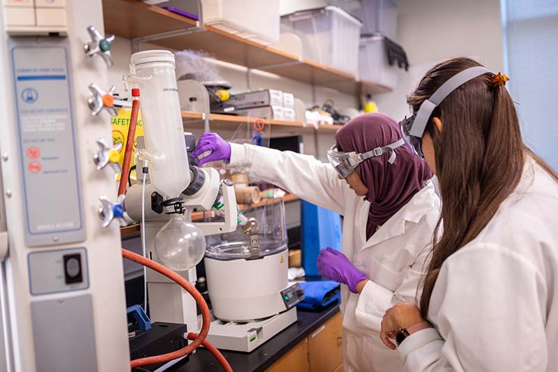 Two Students Performing Research in Chemistry Lab.