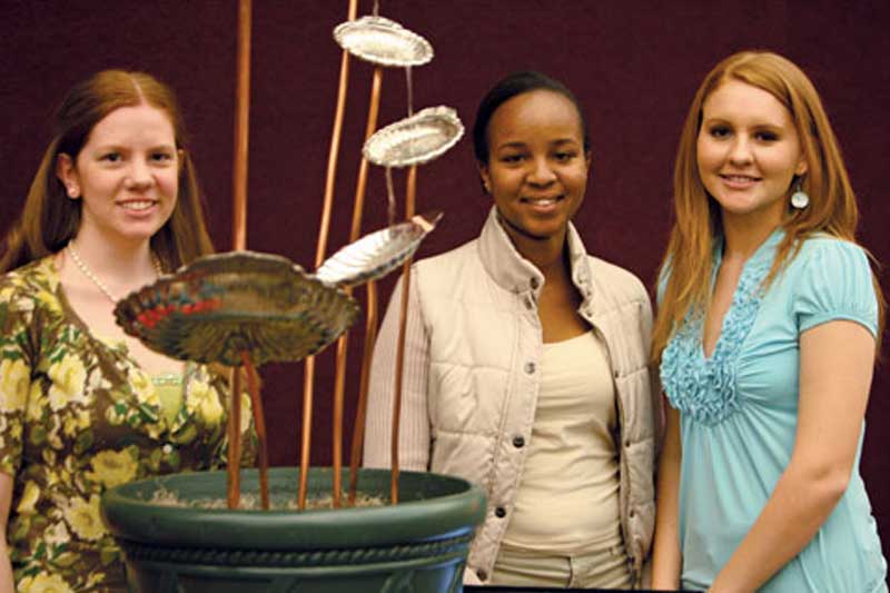 Engineering students next to a display.