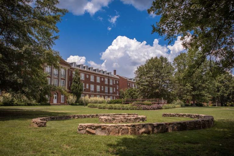Campus common area showing the Fire pit and Volleyball courts with Vann and Stringfield dorms visible in the background.