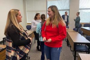 news director networking with COM student after panel.