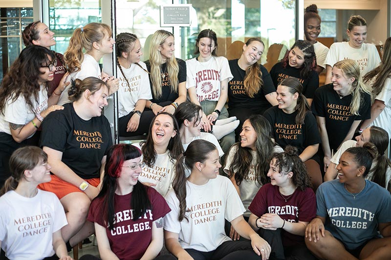 A group of Dance Students Gathered Together laughing and smiling with expressive faces.