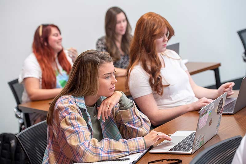 Four students work in an MBA class.