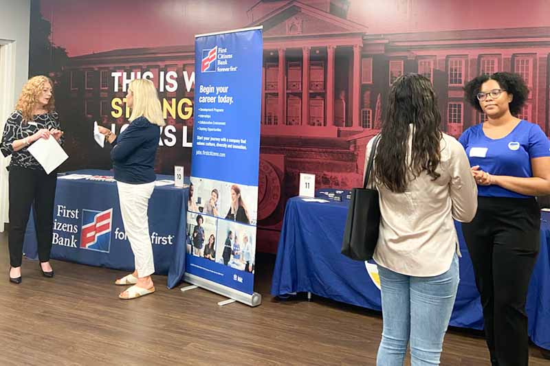 Employer representatives at Cate Student Center speaking with a student.