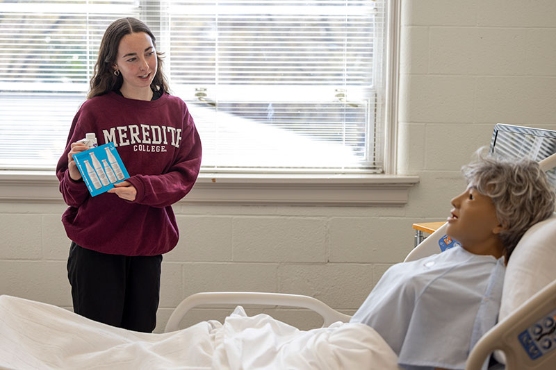 Student Discussiong Health with a Dummy Patient in MSN Lab Training