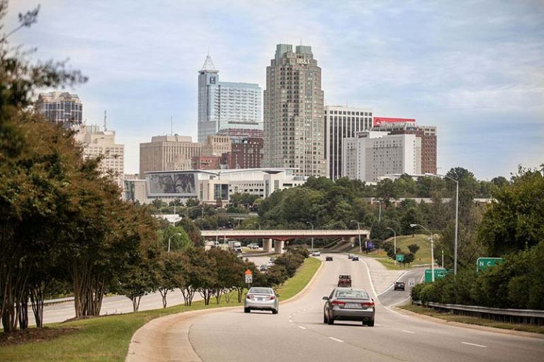 Street View of downtown Raleigh NC showing Convention Center, BB&T Building, Red Hat building and assorted apartment buildings with cars moving along S. Saunders street.