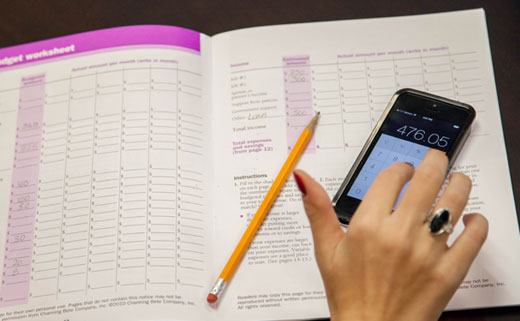 A student doing calculations on a financial workbook.