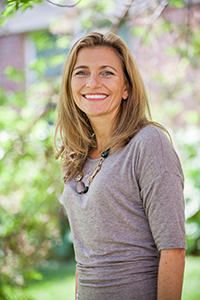 Tracy Smith Smiling with green plants visible.